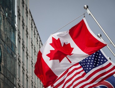 Canada and U.S. flags in the breeze